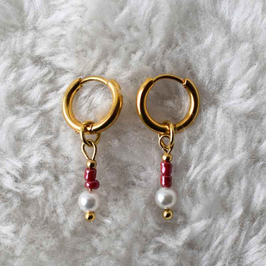 Stalen oorringen goudkleurig met bordeaux rode kralen hanger en parel looks - Idhuna Jewels