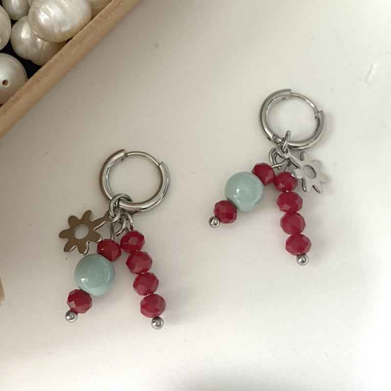 Stalen oorringen met kralen hangers rode facet glaskraal en lichtblauwe keramiek kraal en bloemetje - Idhuna Jewels